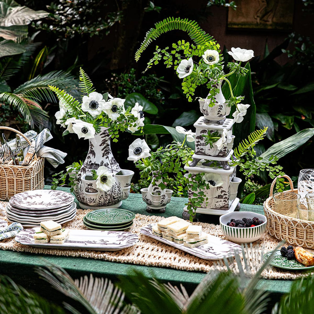 Country Estate flint tulipiere vases alongside country estate plates and trays on an outdoor table.