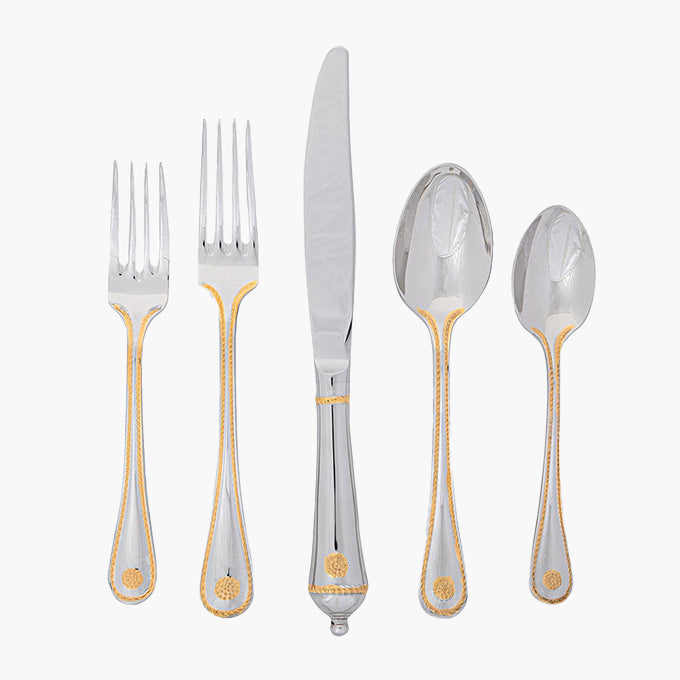 Set of silver cutlery with gold accents on a white background