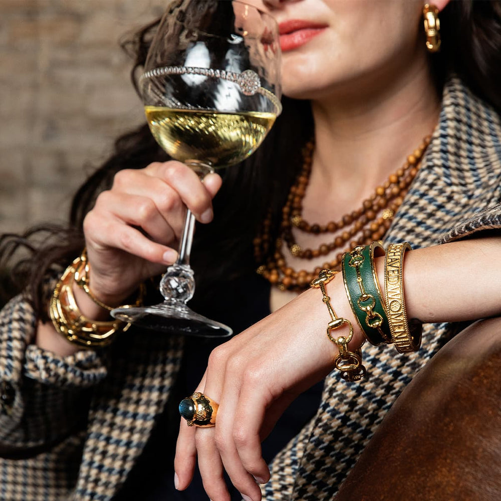 Woman wearing a herringbone blazer drinks from a Graham wine glass.