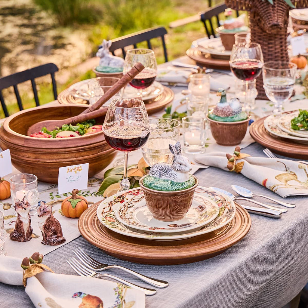 Forest walk themed table setting with animal ceramics, colorful woodsy plates, and graham glassware