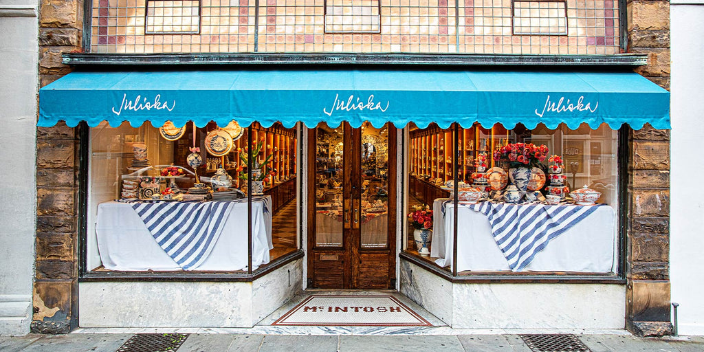 Front view of the Charleston Juliska Store with teal awnings and gorgeous window displays.
