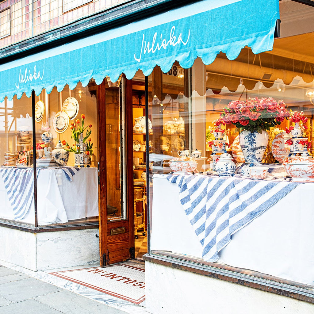 Front view of the Charleston Juliska Store with teal awnings and gorgeous window displays.