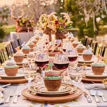 Decorative table setting with stag, woodland themed dinnerware and glasses outdoors.