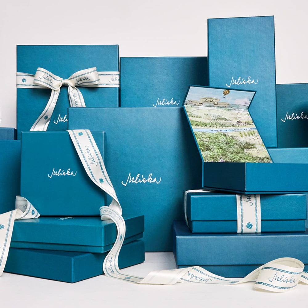 Collection of blue gift boxes with ribbons and 'Juliska' branding on a white background