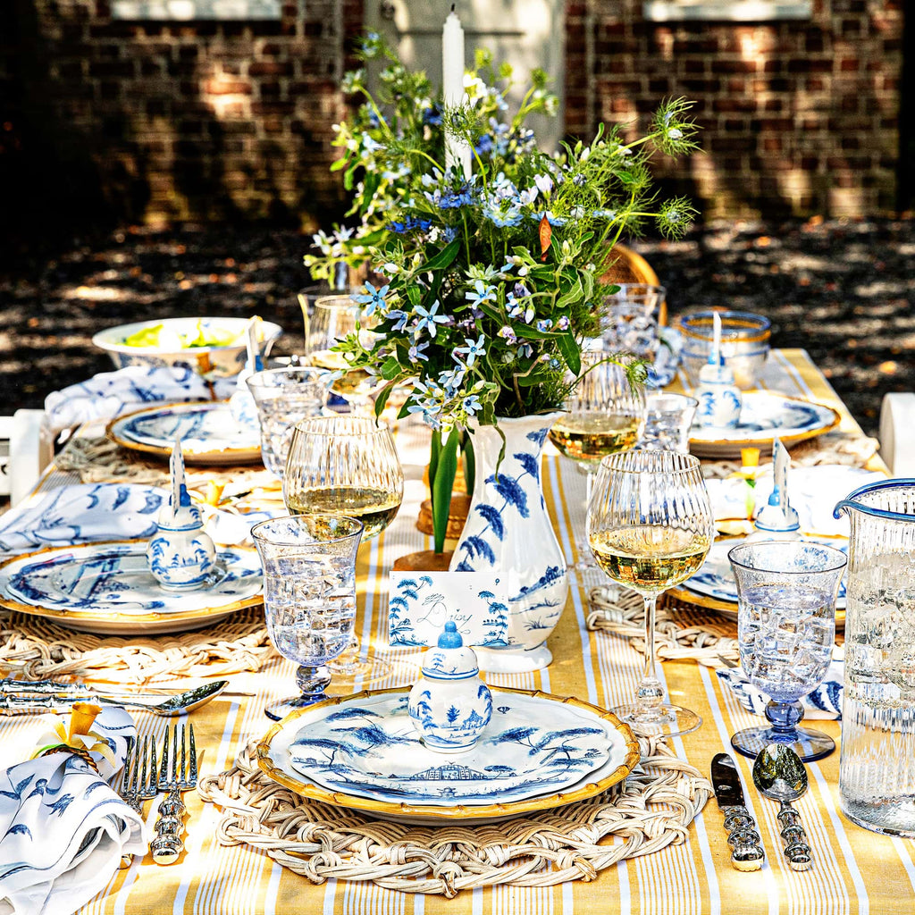 Country Estate Delft Blue and Bamboo Ceramics featured within an outdoor tablescape. Rattan placemats, cabana tablecloth and meadow walk are also featured