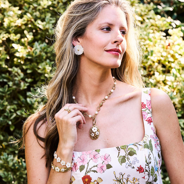 Woman in floral dress wearing Capucine De Wulf jewelry