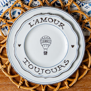 Two L'Amour Toujours plates stacked on a rattan placemat