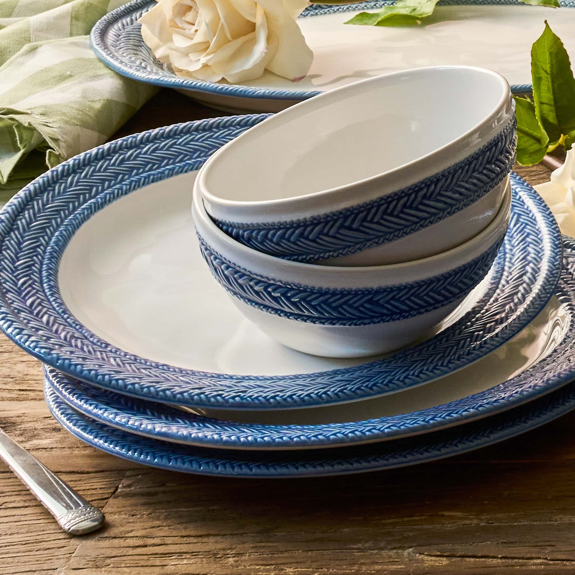 Set of blue and white ceramic plates and bowls on a wooden table.