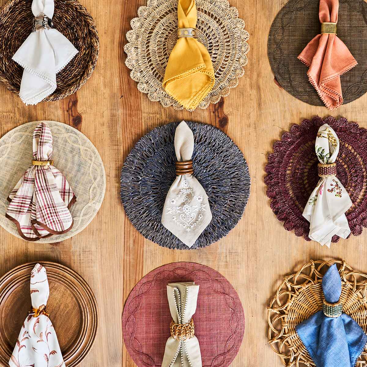 Napkins, napkin rings, and placemats displayed on a wooden table