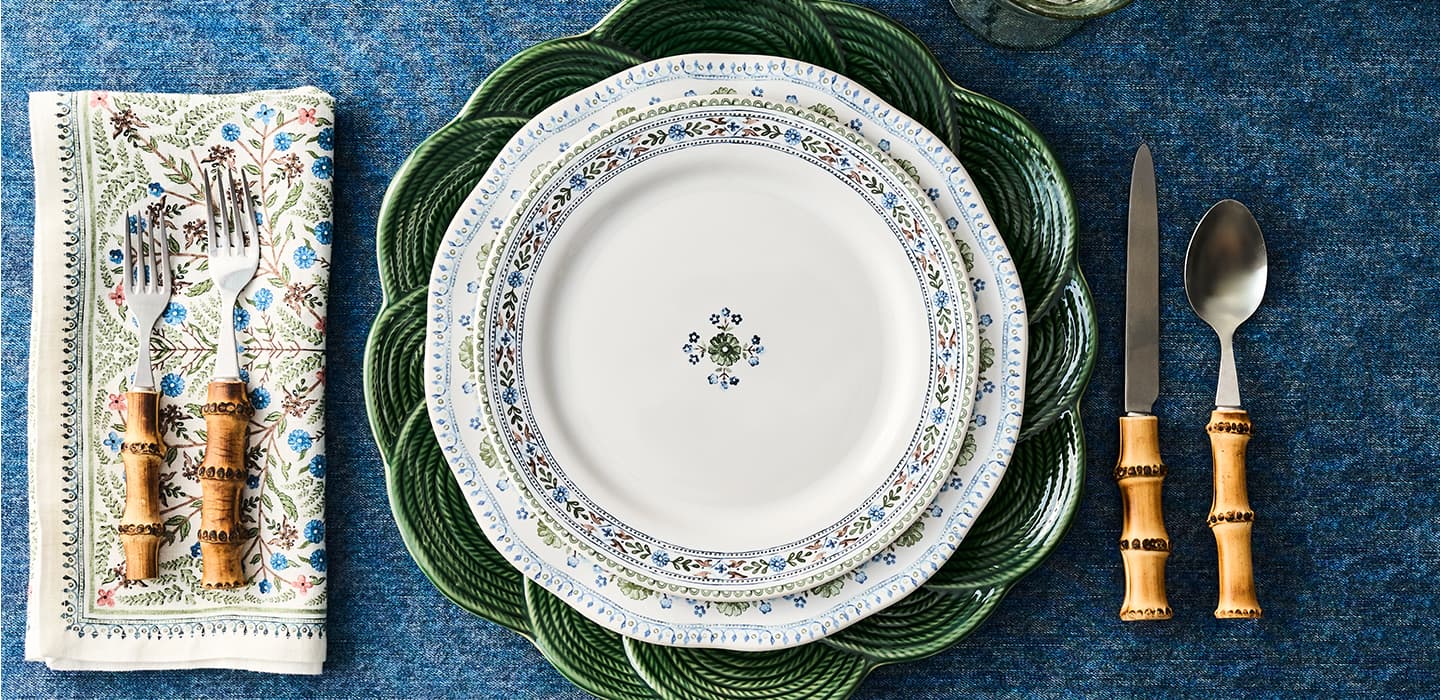 Set of dinnerware with floral patterns on a blue textured surface