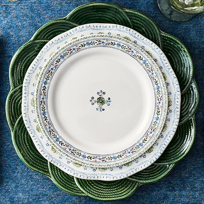 Set of dinnerware with floral patterns on a blue textured surface