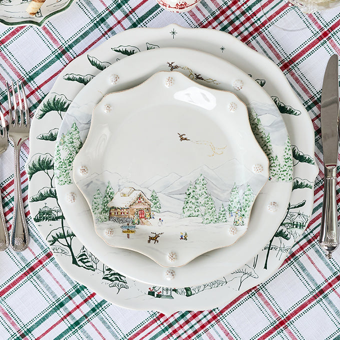 Decorative Christmas-themed plate set on a plaid tablecloth with silverware.