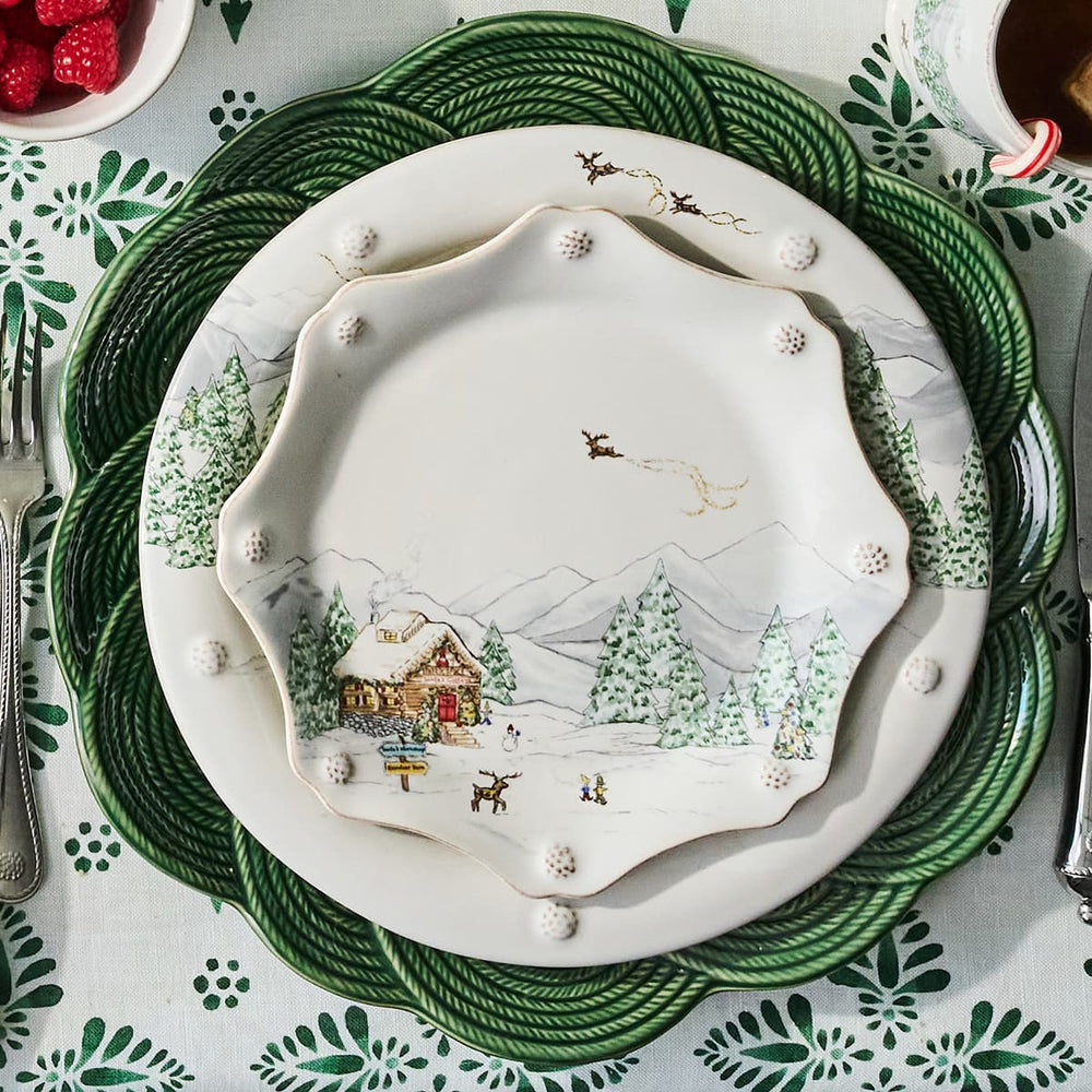 Decorative Christmas plate with a winter scene on a patterned tablecloth.