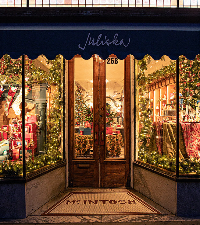 Decorative storefront with Christmas decorations and lights, featuring the brand 'Juliska'.