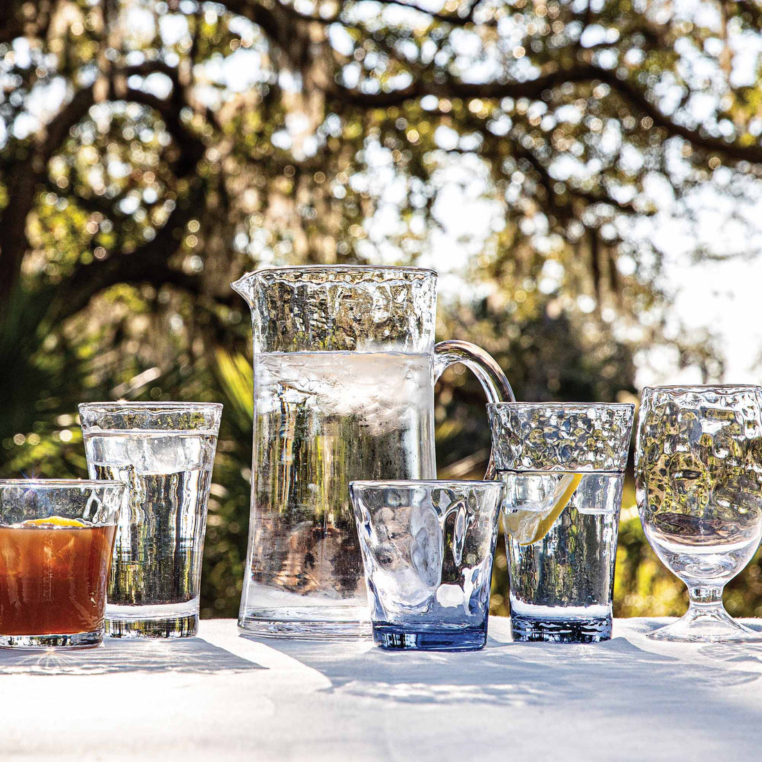 Variety of Juliska drinking glasses resting on an outdoor table