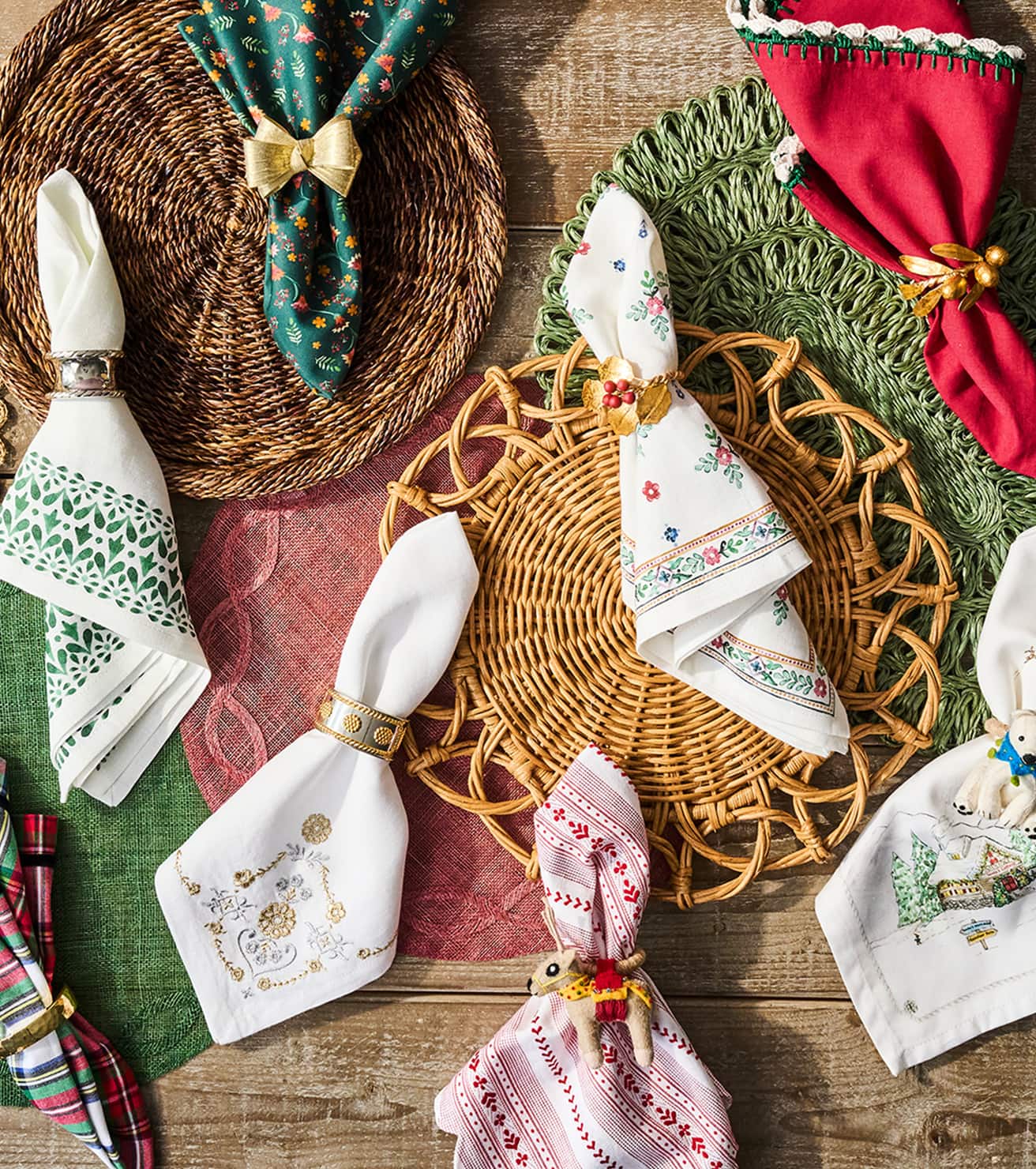 Decorative table setting with embroidered napkins on woven placemats.