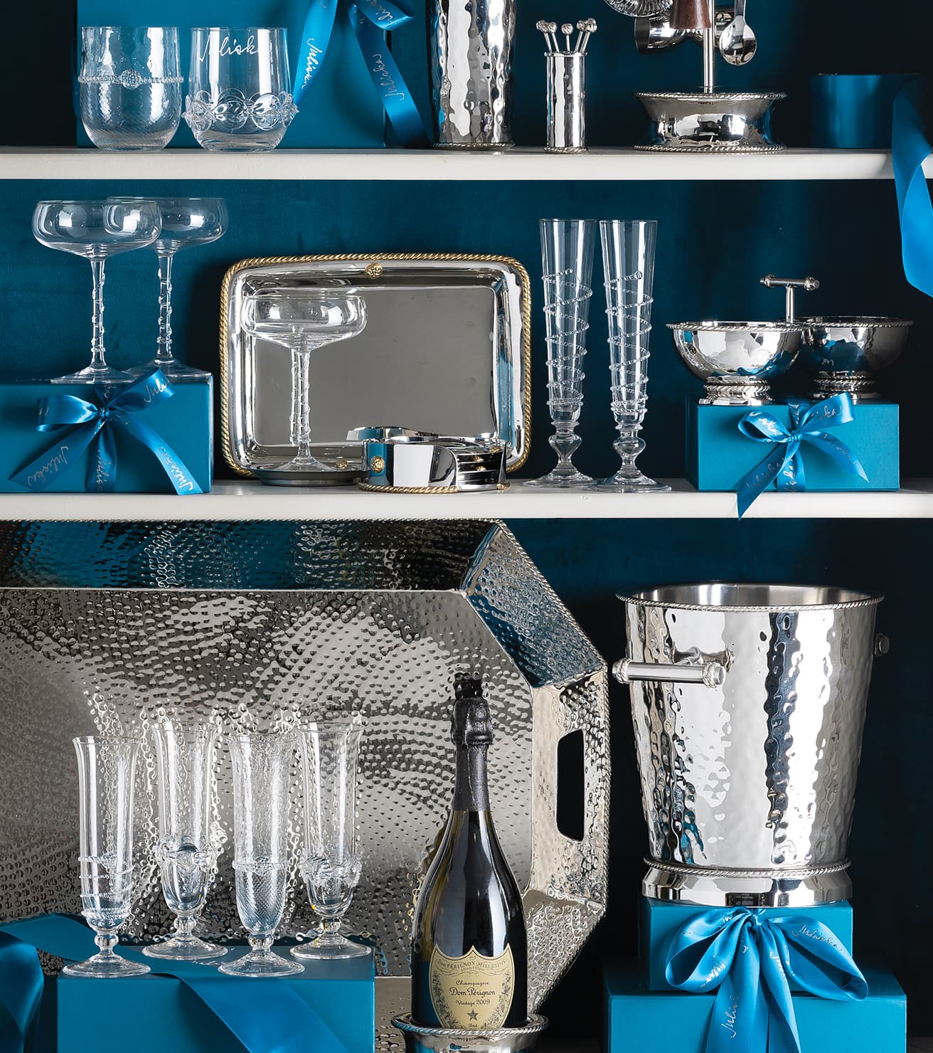 Decorative setting with silver glasses, bottles, and containers on a blue background