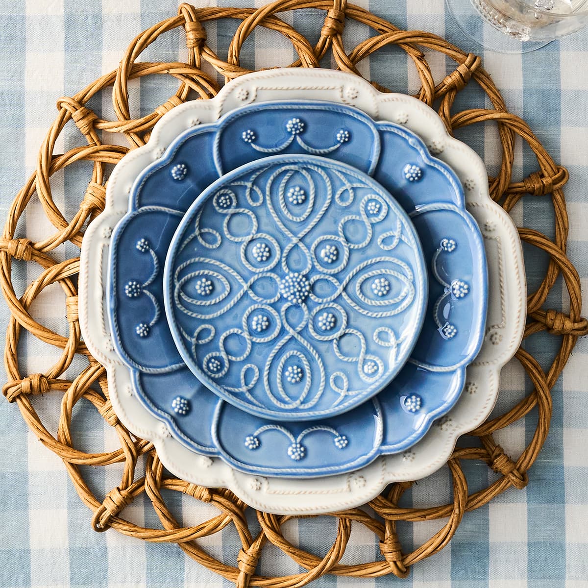 Picture of blue and white plates stacked on a blue gingham tableboth