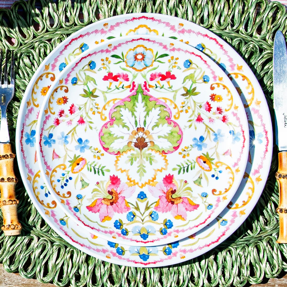 Two Sofia plates stacked on a green rattan placemat