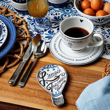 A coffee cup with a heart inside and a Love Always tray on a blue and white tablescape.