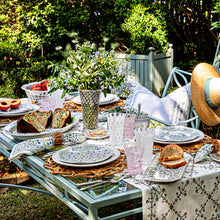 Outdoor tablescape featuring trellis glassware, villa seville, and rattan placemats. 