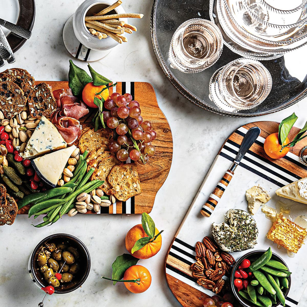 Two stonewood stripe charcuterie boards and a graham metal serving tray displaying beverages