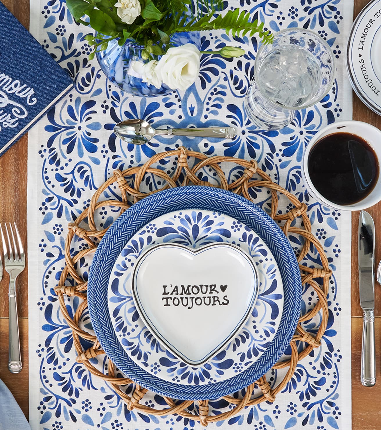 Table setting with blue and white plates, floral centerpiece, and coffee cup.