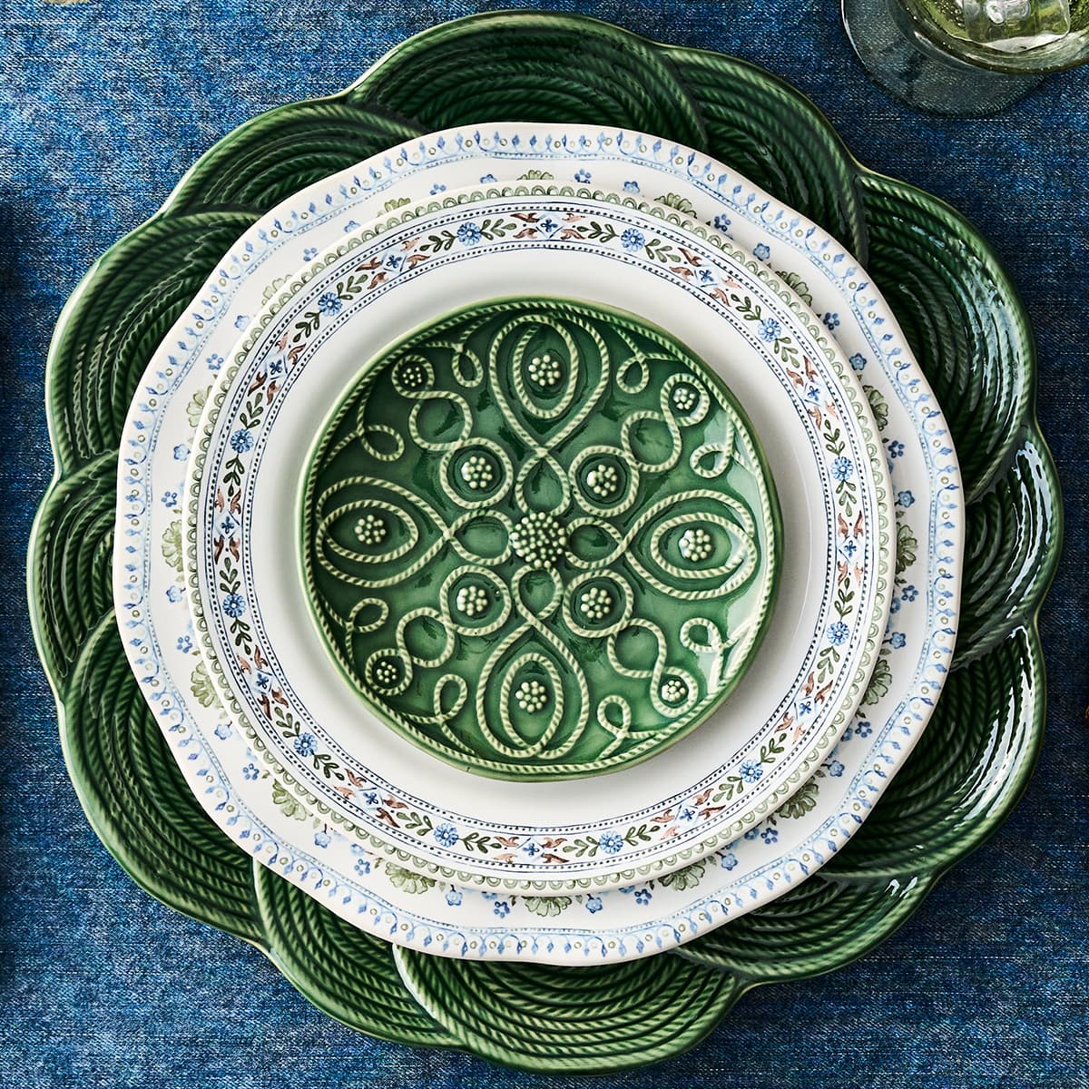 Stack of decorative plates with intricate patterns on a blue textured surface