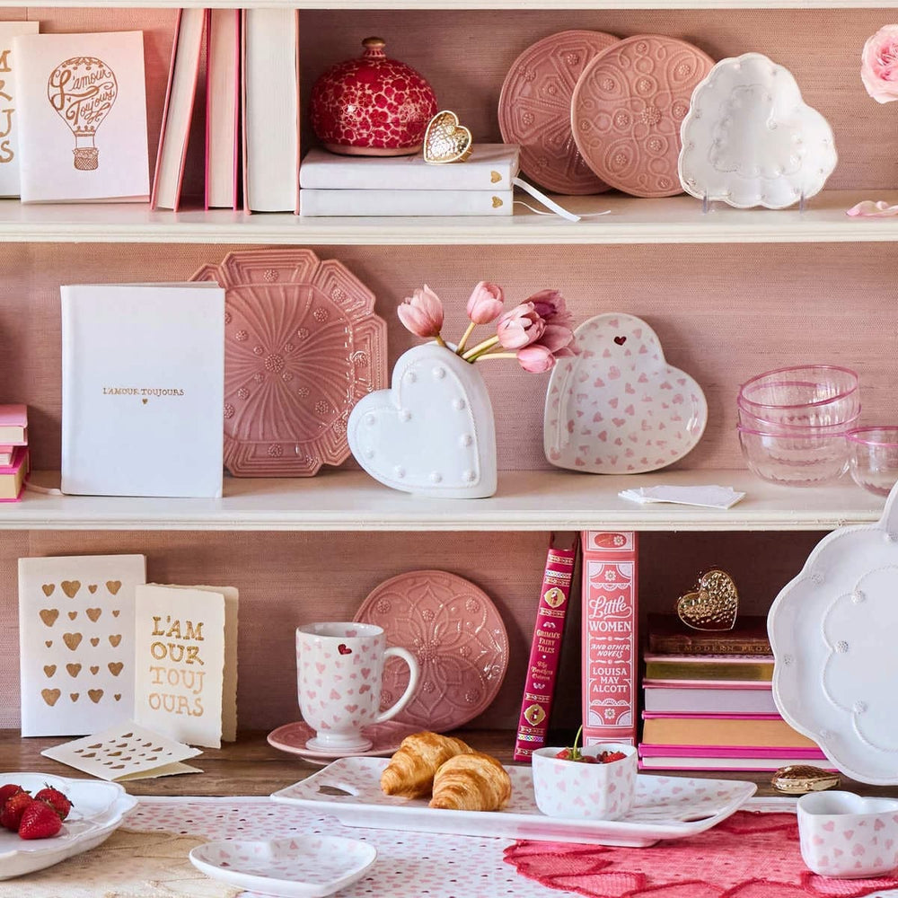 Shelving unit with decorative items including plates, mugs, and books on a wooden surface.
