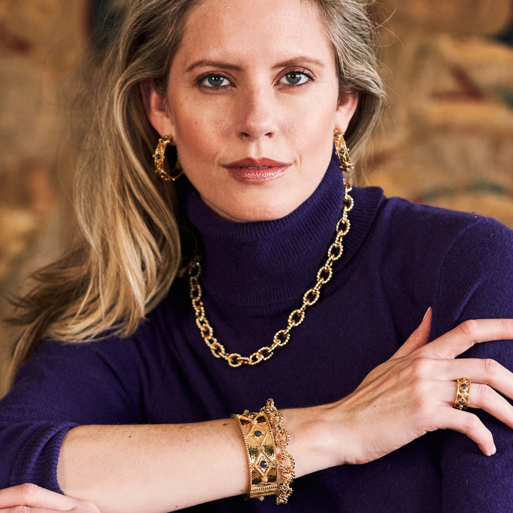 Woman in purple turtleneck modeling the victoria collection jewelry