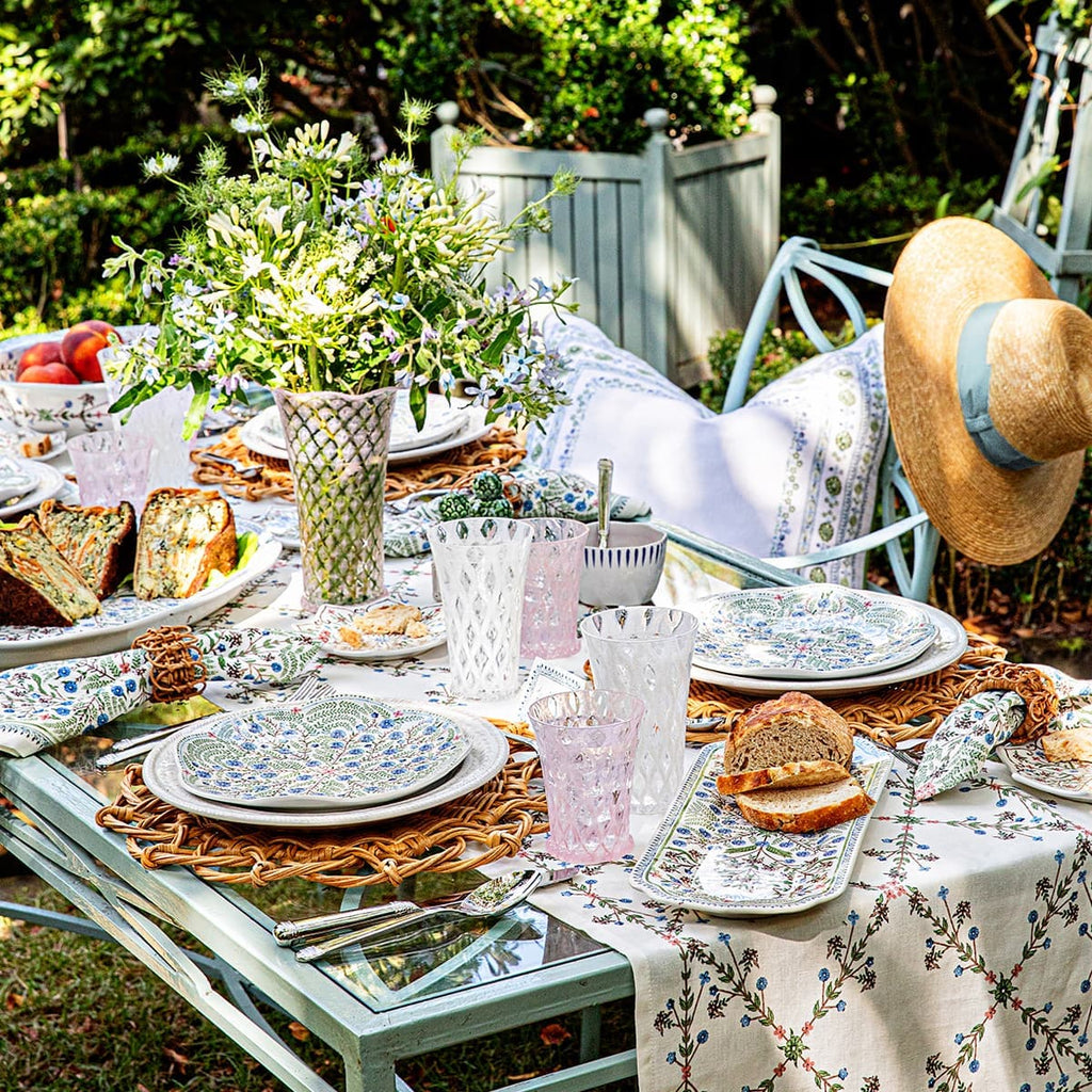 Villa Seville ceramics and linens displayed within a tablescape in an outdoor garden 