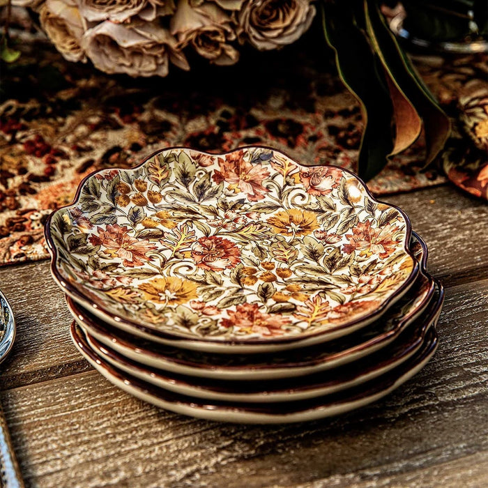 Stack of decorative ceramic plates with floral patterns on a wooden surface.