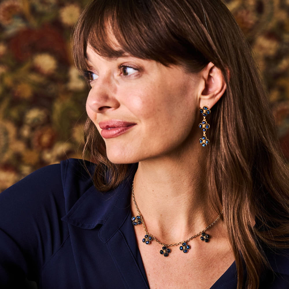 Side profile of a woman wearing blue earrings and necklace