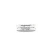 A pair of hammered silver rings stacked together on a plain white background.
