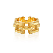 A gold-toned textured link ring with a geometric, interlocking chain-link design, shown on a clean white background with a soft reflection.