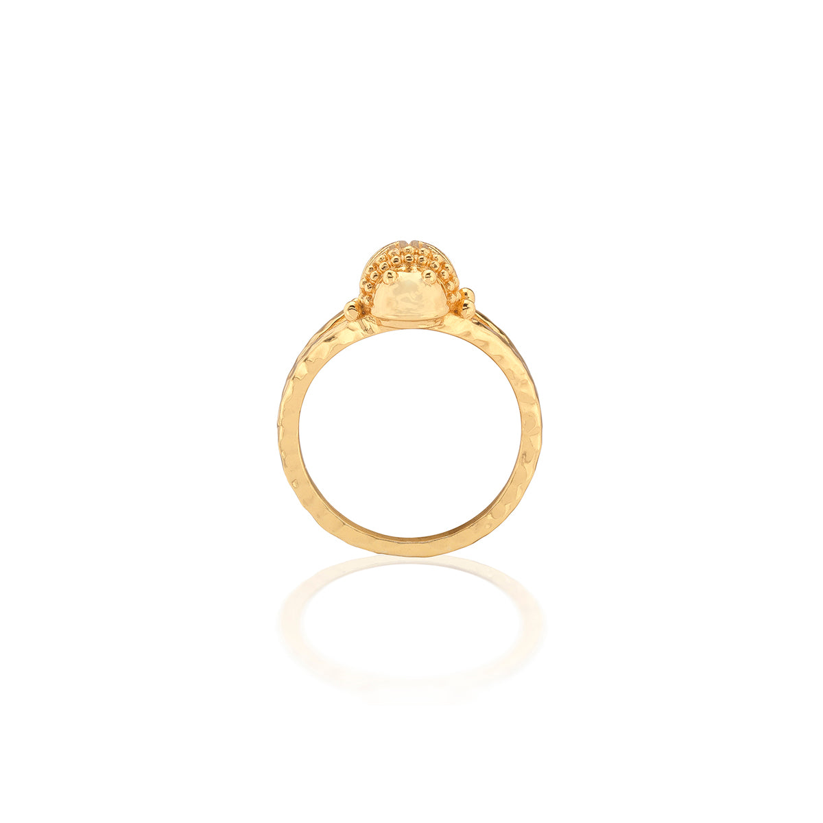 A gold ring with a textured band and a dome-shaped setting featuring small clear stones, shown against a plain white background with a soft reflection below.