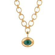 A gold chain necklace with textured oval links and a central gold pendant featuring a green stone in an oval setting, shown on a plain white background.
