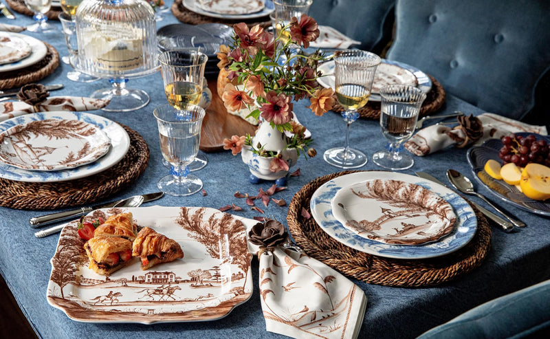 Load video: Video of a layered table setting featuring classic blue and white patterns, rich denim hues, handcrafted ceramics, and natural textures in a relaxed, refined setting.