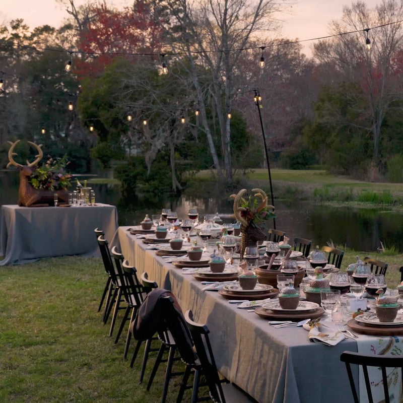 Load video: A video of Thanksgiving table setting with wine glasses, plates, and decorative elements outdoors.