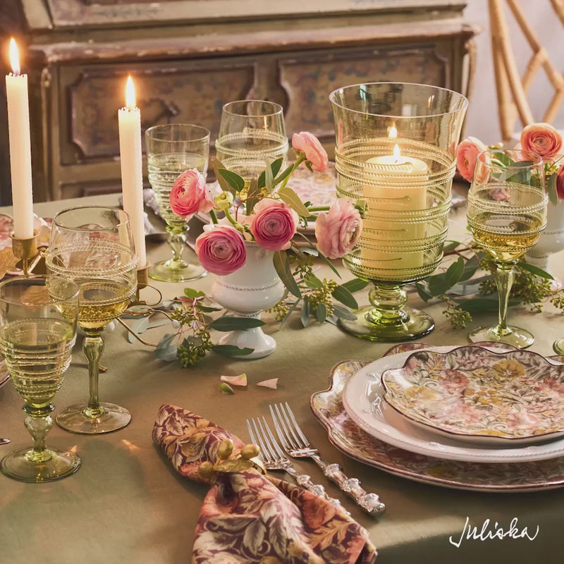 Load video: Video panning over tablescape with sage green tablecloth, green glassware, white and autumnal plates. The video features close up on glassware, barware and linens.