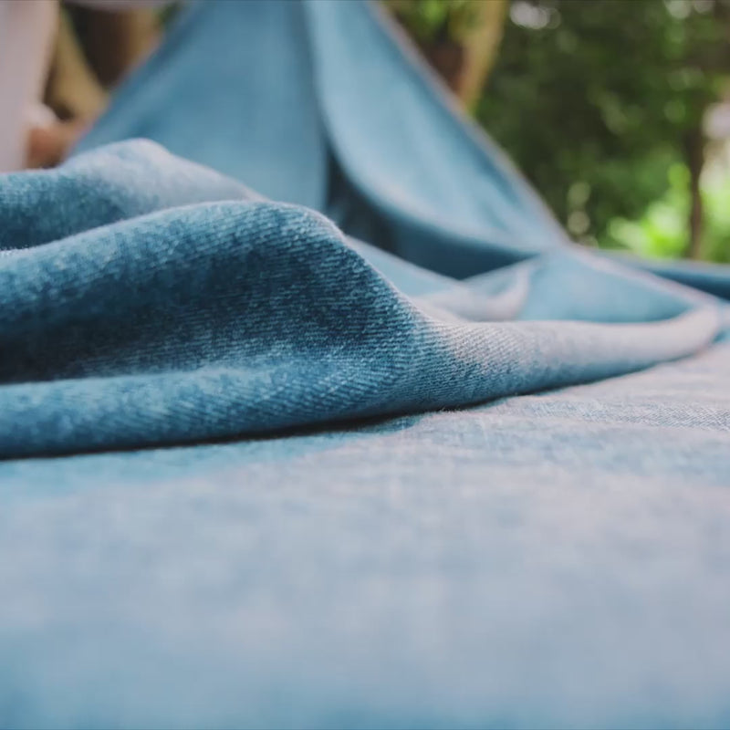 Video featuring green and blue plates within a tablescape with floral arrangements in the center. 
