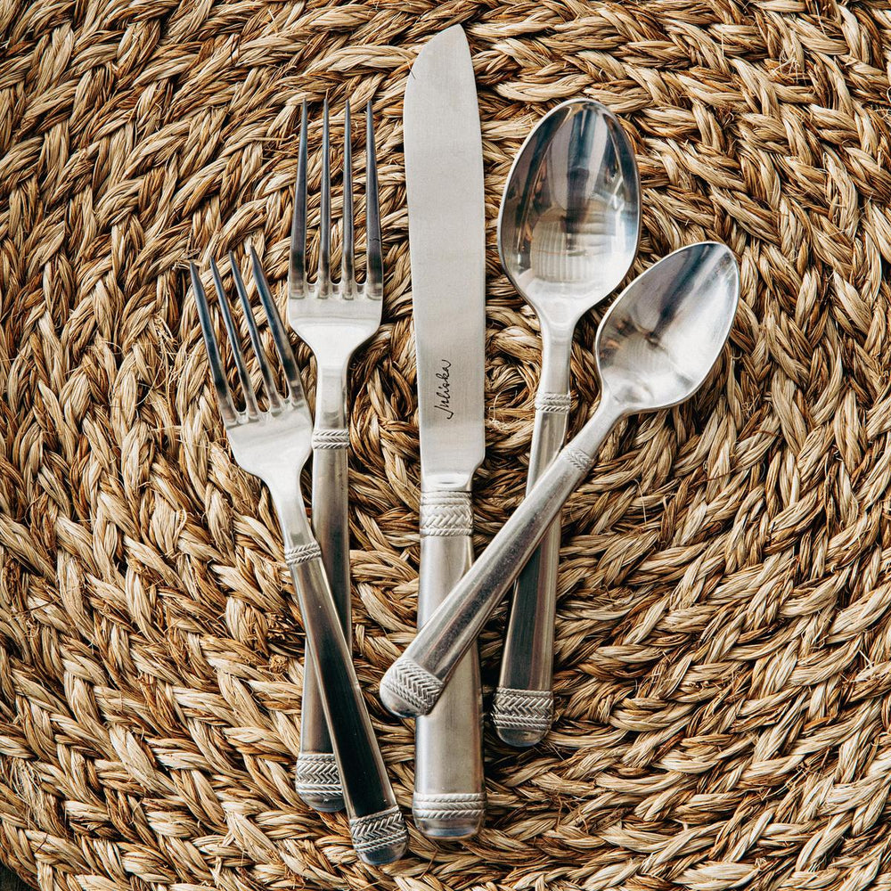 Le Panier flatware on a woven placemat.